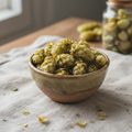 Dried hops flowers in a rustic ceramic bowl on natural linen